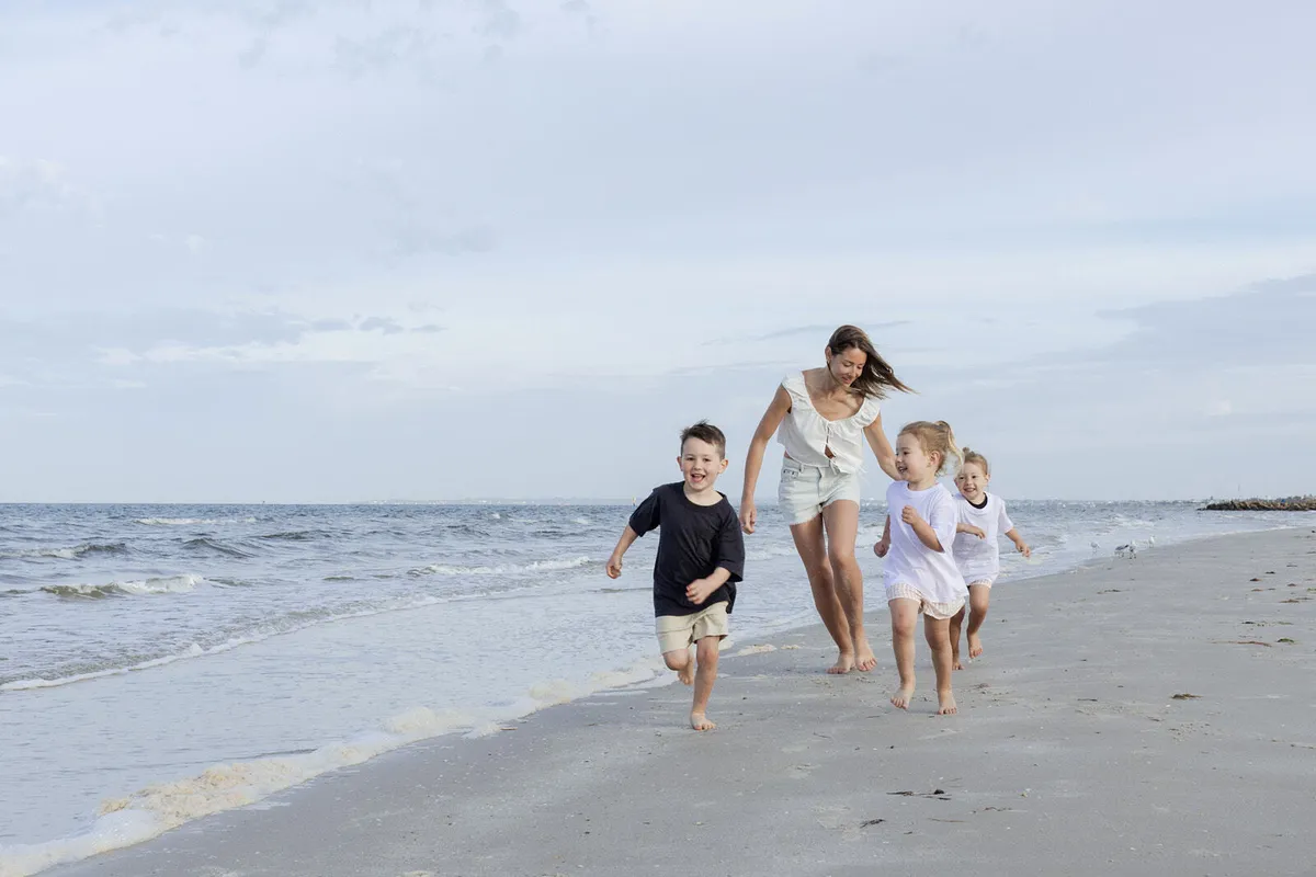 Beckham, Allie and the twins, Indi and Harper, running along the beach