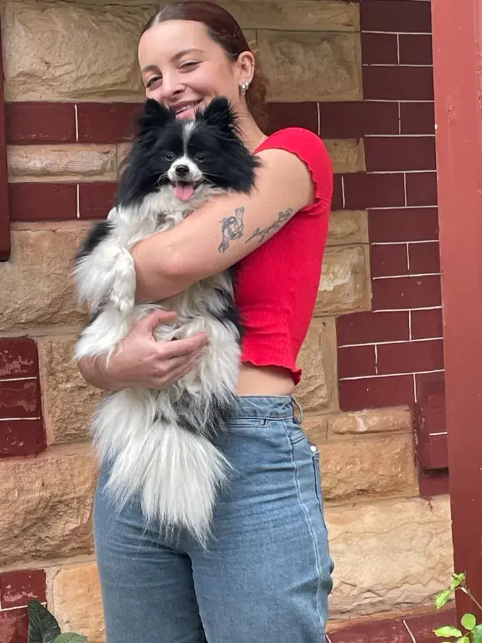A team member hugging their fluffy black-and-white dog
